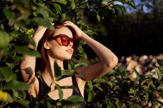 pretty woman wearing sunglasses green leaves glamor posing summer. High quality photo