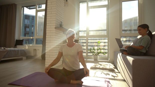 Young woman at home stretching out after exercising