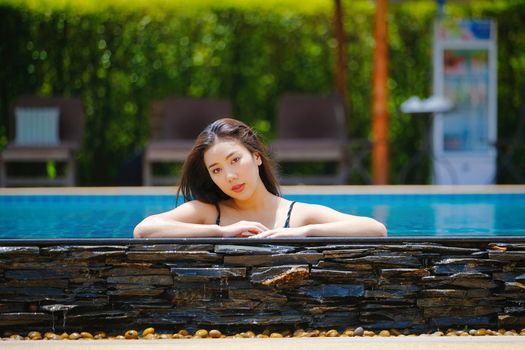 Beautiful southeast asia woman in pool relaxing