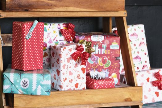 Lots of gift boxes put on a wooden shelf for Christmas