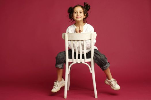 Photo of smiling little girl child isolated over pink background. Looking camera.