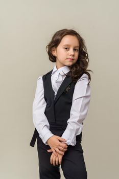 Photo of smiling little girl child isolated over grey background. Looking camera.