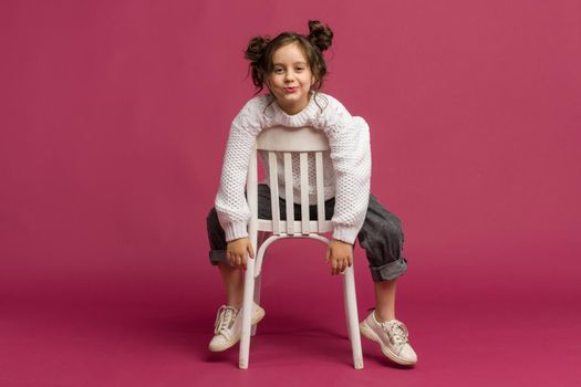 Photo of smiling little girl child isolated over pink background. Looking camera.