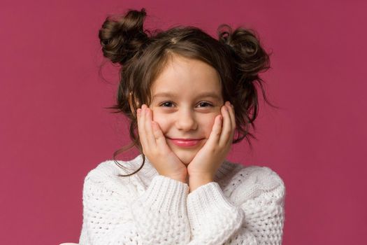 Photo of smiling little girl child isolated over pink background. Looking camera.