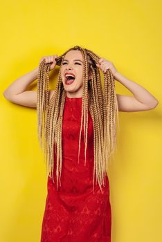 young woman in red dress pulls herself for pigtails and screams