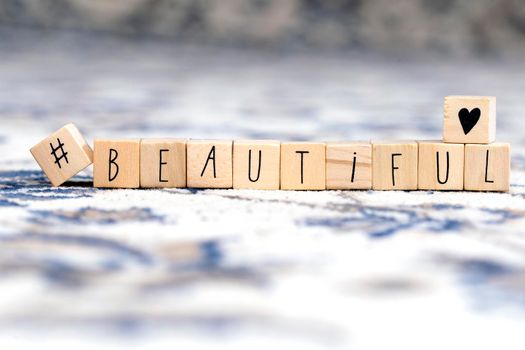 Wooden cubes with a hashtag and the word beautiful, social media concept background beauty