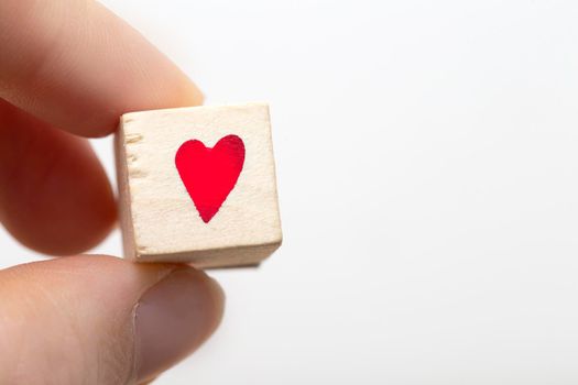 Hand hold wooden cubes with red heart symbol isolated on white background. Emotion concept. space for text