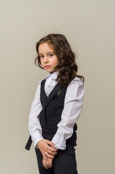 Photo of smiling little girl child isolated over grey background. Looking camera.