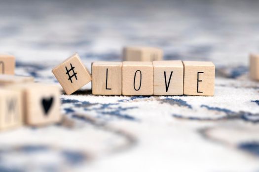 Wooden cubes with a hashtag and the word Love, social media and valentines concept background beauty