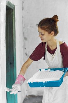 woman painter In white apron home renovation interior. High quality photo