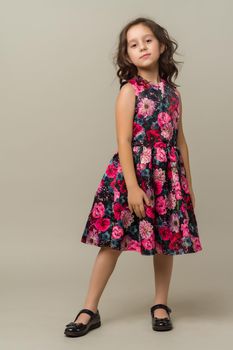 Photo of smiling little girl child isolated over grey background. Looking camera.