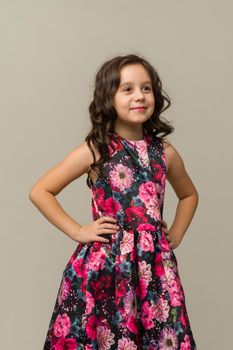 Photo of smiling little girl child isolated over grey background. Looking camera.