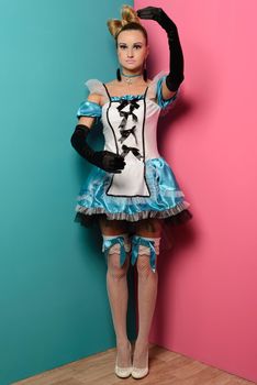 Slim sexy woman doll alice in Wonderland on a pink and blue background