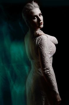 Beautiful girl in white lace negligee. A trace from a mixed light. The Snow Queen. Low key
