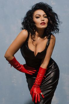 Beautiful fetish model wearing black spandex dress and long red leather gloves.