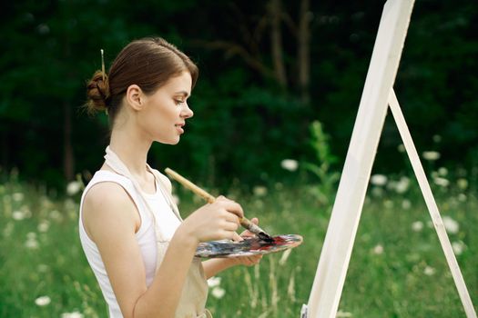 woman outdoors paint a picture landscape hobby creative. High quality photo