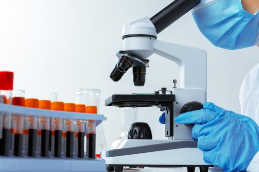 Close up photo of woman scientist working with microscope in laboratory