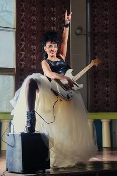 Photo of a female guitarist playing an electric guitar.
