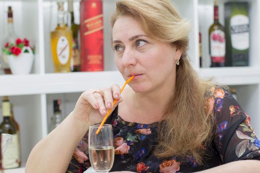 Woman drinking alcoholic cocktail from a straw