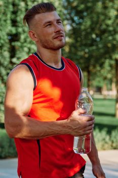 athletic man with dumbbells in his hands outdoors in the park. High quality photo