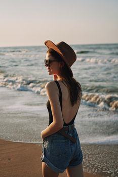 woman walking on the beach hat travel vacation sun. High quality photo