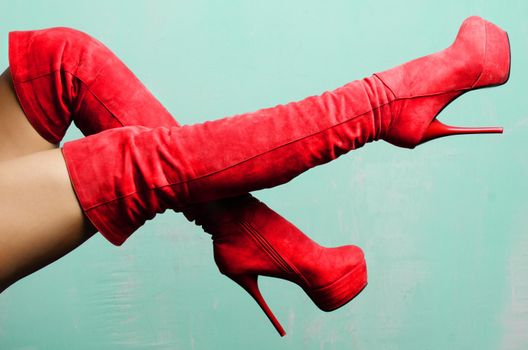 female legs in red suede high-heeled boots.