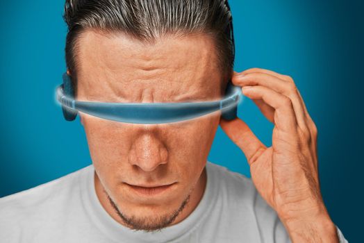 Serious man in cyber glasses, futuristic concept