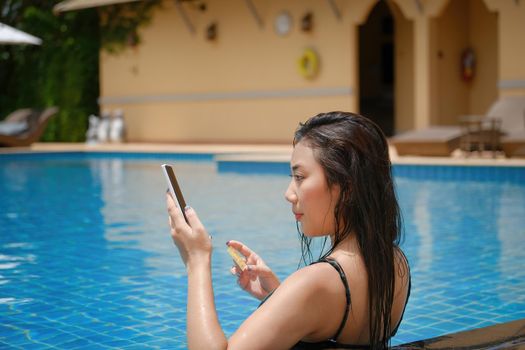 online payment, A teenage girl who swims is using her smartphone with her credit card to make purchases. online via internet