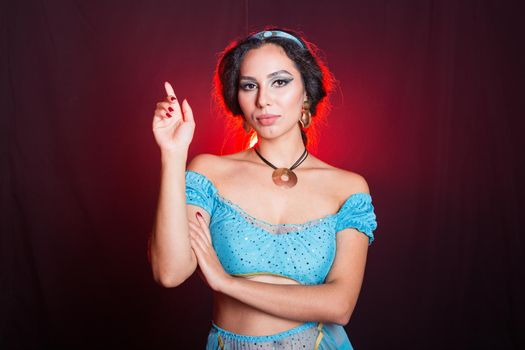 Portrait of a young woman in the image of an Eastern fairy Princess on dark background