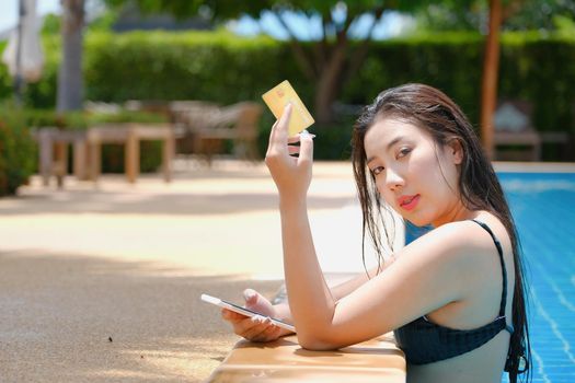 online payment, A teenage girl who swims is using her credit card with her phone to make purchases. online via internet