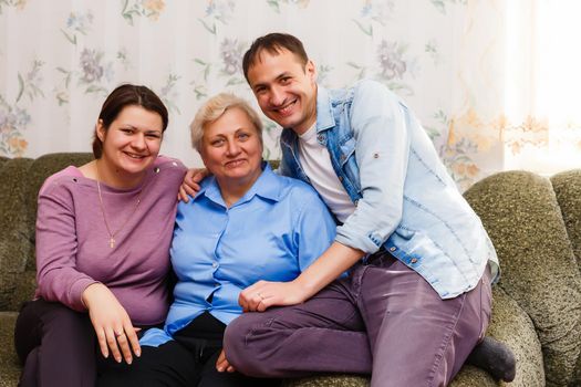 mother With Adult Children Relaxing On Sofa At Home Together