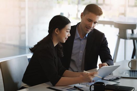 Female advisors use tablets to suggest marketing channels for male business owners to restructure their investments