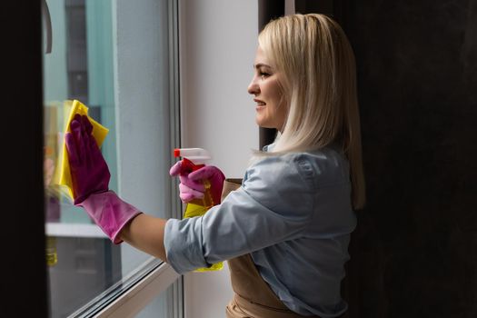 The woman washes a window in apartment