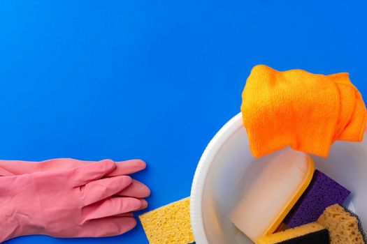 House cleaning supplies on blue color background, top view