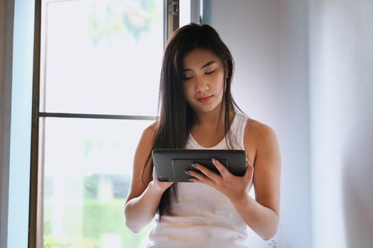 new normal, a businesswoman using tablet work for a company Via the internet on your desk at home