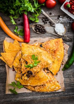 quesadilla with spices and vegetables on a wooden background