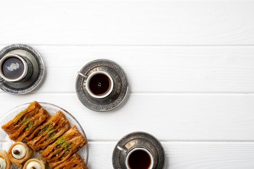 Top view of Turkish sweets and Turkish coffee on white wooden background, close up