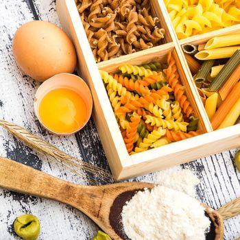 different kinds of pasta and products on textured wooden table