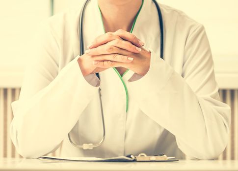 psychotherapist sitting at the workplace with her hands crossed