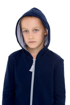 Portrait of boy in blue hoodie with serious face. Stylish preteen boy looking at camera posing in front of grey background. Handsome child wearing hooded sweatshirt