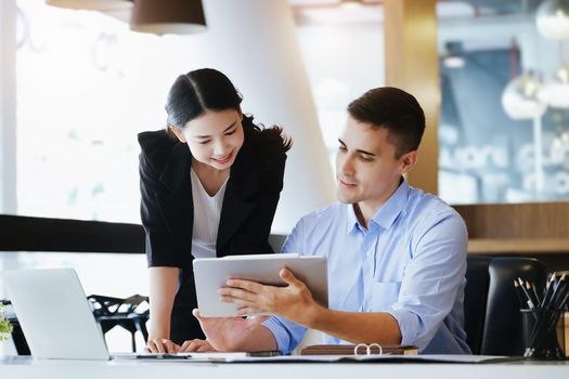 The male marketing manager expressed his satisfaction in selling the company's products. where team members show sales from their iPad screen