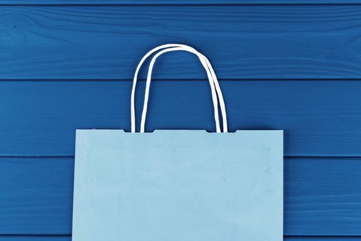 Blue shopping bag on blue background, top view. Close up.