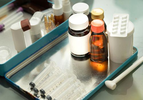 Variety of medicine package on tacle includes bottle spray MDI syrup syringe on blur background