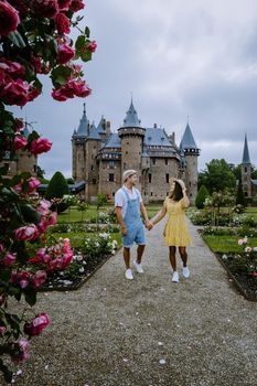 Castle de Haar Utrecht, couple men and woman mid age European and Asian visit De Haar Castle in Dutch Kasteel de Haar is located in Utrecht Netherlands during Spring with flowers in the garden