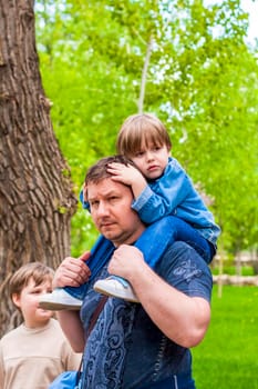 A male father spends time with his young son. Family walks in nature. The joy of being together.