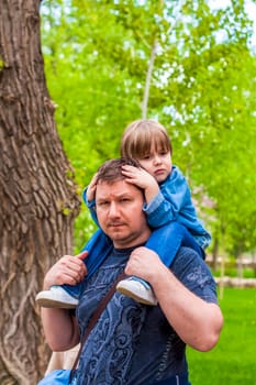 A male father spends time with his young son. Family walks in nature. The joy of being together.