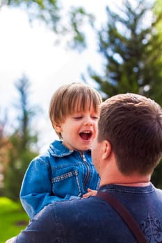 A male father spends time with his young son. Family walks in nature. The joy of being together.