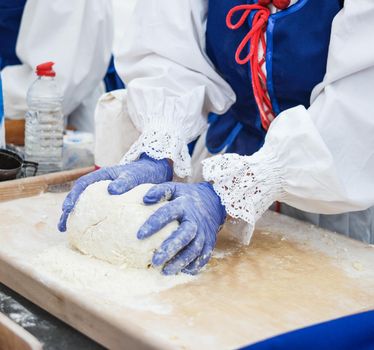 kneading the dough on an outside cooking fair