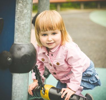 cute little girl on a swing on playground