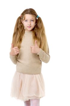 A beautiful girl of ten years of age. Pretty blonde with pigtails in a knitted jumper and skirt, looking at the camera, posing on a white background.